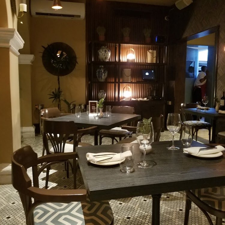 Interior de madera con mesas vestidas y exhibidor de vinos