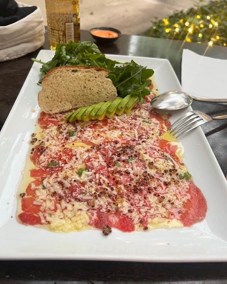 Milanesa gratinada sobre plato blanco con vegetales